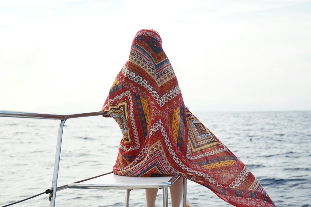 woman sitting on chair beside sea
