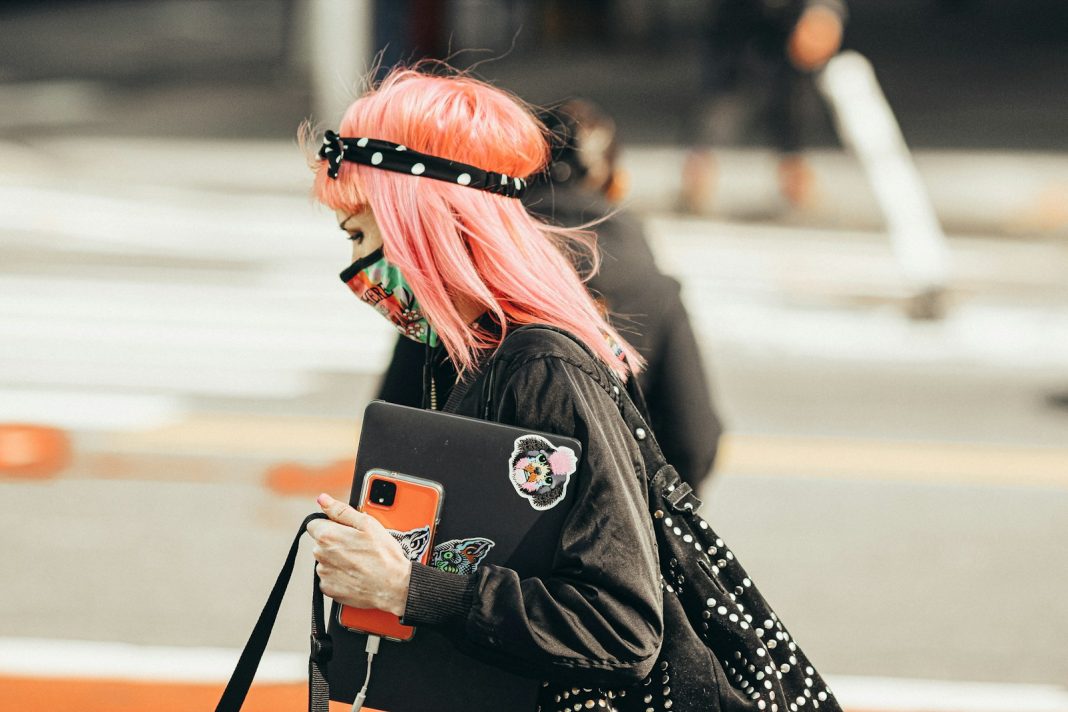 woman in black and white long sleeve shirt holding silver iphone 6