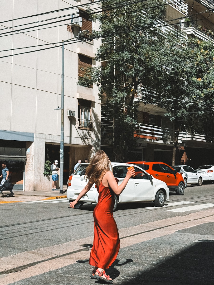 A woman in a red dress crossing the street